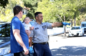 Anthony from Caccia is standing with a client and his baby on a nice, sunny street pointing out aspects of the California plumbing infrastructure.