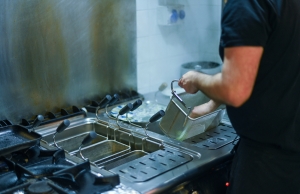 Restaurant cook emptying a basket from the fryer