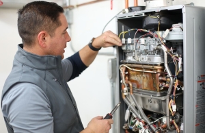 An expert from Caccia Plumbing works on a tankless water heater.