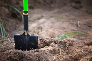 Shovel inserted in ground while looking for septic tank