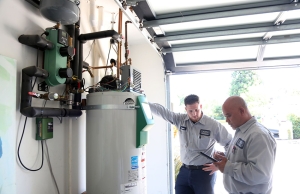 Caccia Plumbing checks out a water heater at a customer's home.