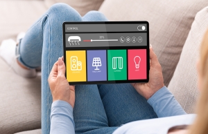 A woman navigates a smart home and automation hub on her tablet.