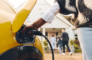 A woman in California plugs in her electric vehicle after arriving home.