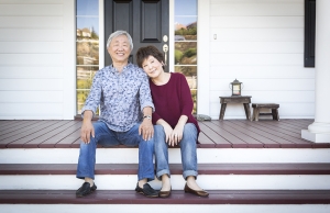 A happy couple sit outside their San Mateo home in late fall