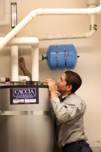 Johnathan from Caccia Plumbing works on a hot water heater.