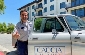 Geno from Caccia Plumbing stands near his work truck smiling, ready to help with an old electrical panel upgrade.