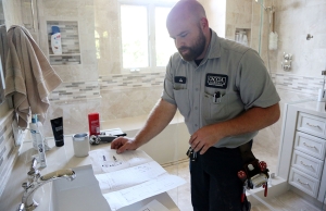 Joe from Caccia Plumbing works on a customer's bathroom fixtures.