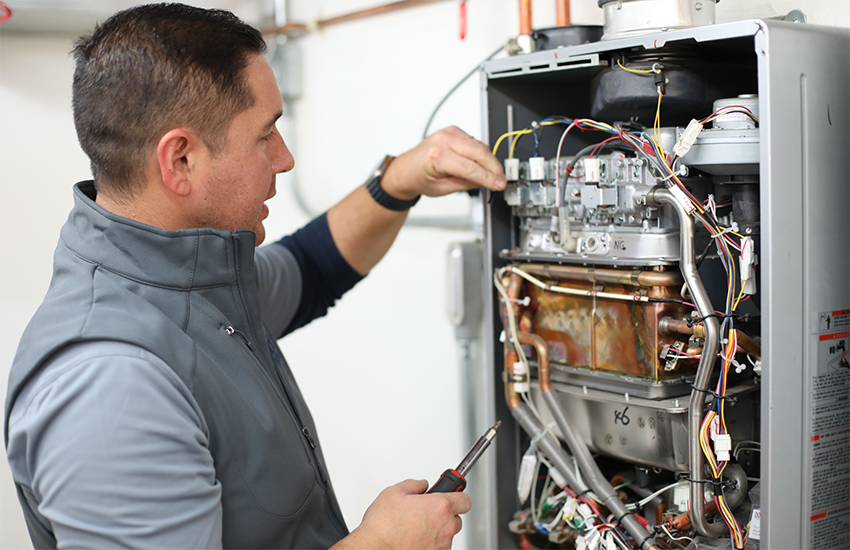 A Caccia Home Services rep inspects a tankless water heater.