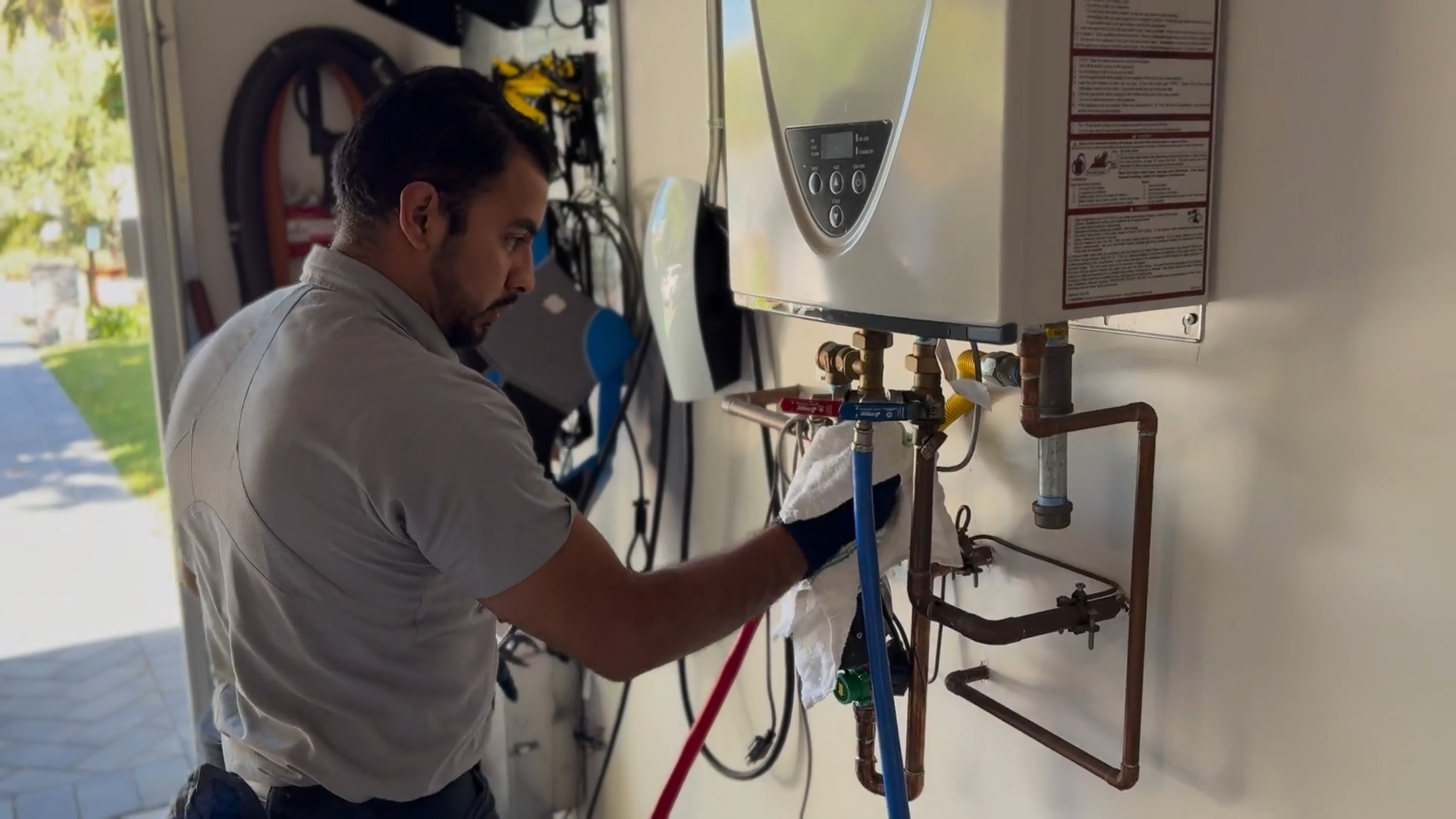Cristian connects the red and blue pressure hose to the isolation service valves.