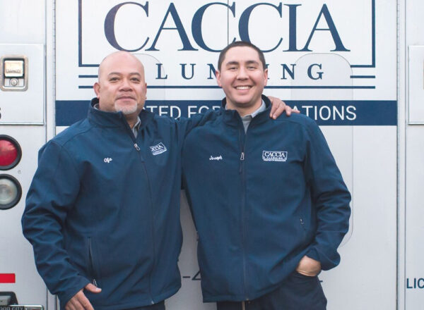 Two Caccia Plumbing plumbers in front of a service truck
