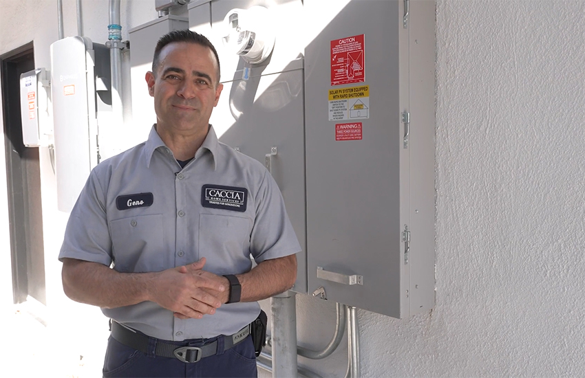 Geno smiling next to a new electrical panel 