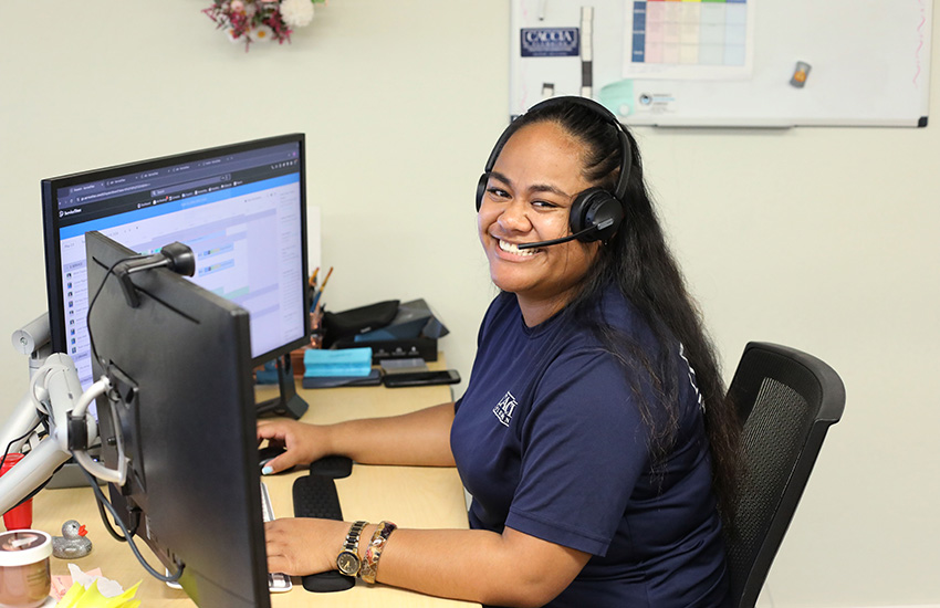 caccia-customer-service-rep Veitoa from Caccia Home Services smiles from her desk