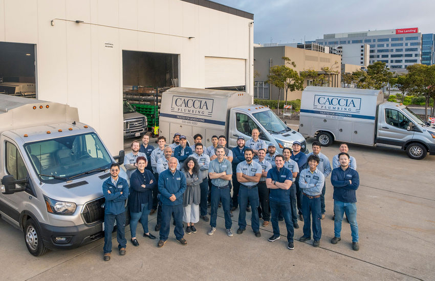Overhead shot of the whole Caccia Home Services crew standing by service trucks in parking lot