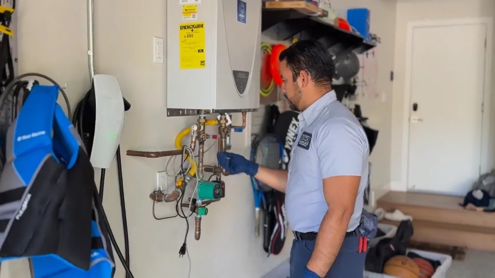 Cristian connects the red and blue pressure hose to the isolation service valves.