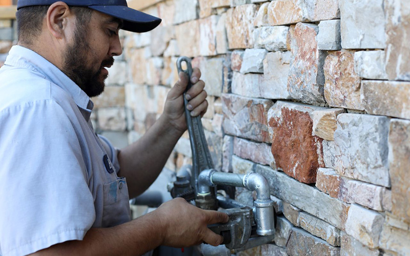 A Caccia technician works on a customer's gas line inspection