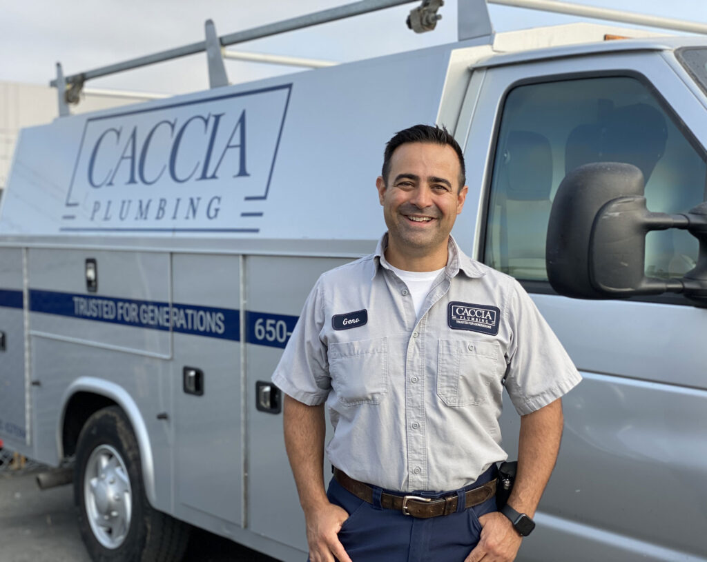 Geno Caccia of Caccia Plumbing, smiling in front of a Caccia service truck.