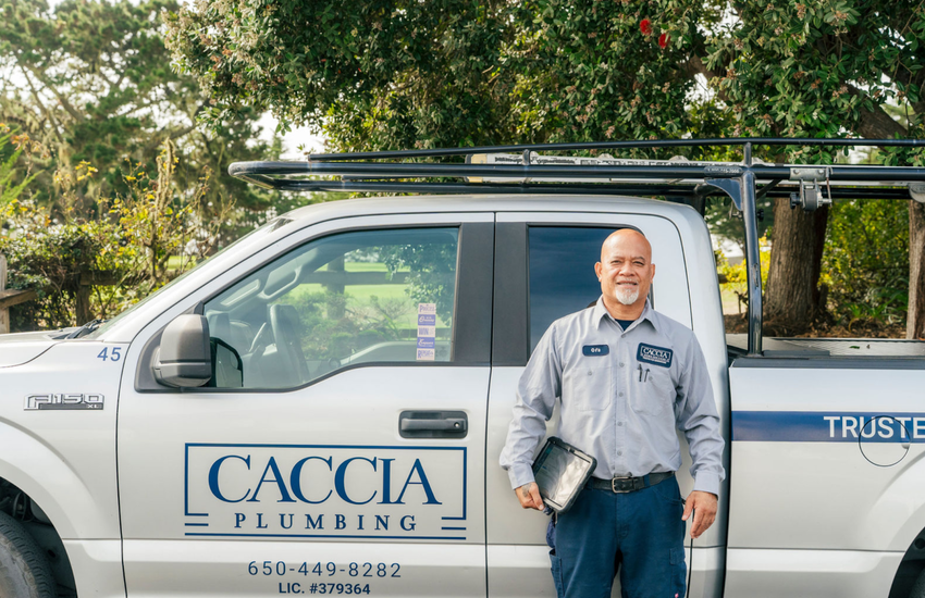 Ofa from Caccia Home Services stands smiling in front of his truck on a sunny day.