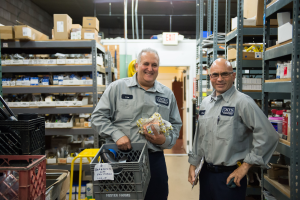 Lou and David from Caccia Home Services stop to chat while grabbing supplies from the warehouse before heading out on a service call.