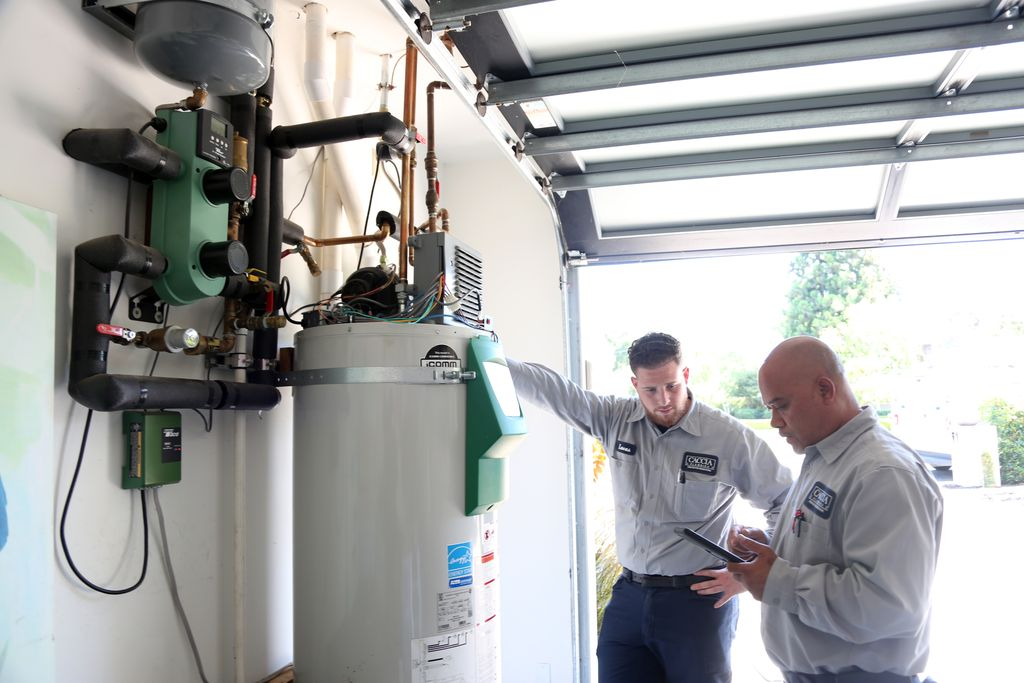 Plumbers from Caccia Home Services check the pressure on a customer's water intake