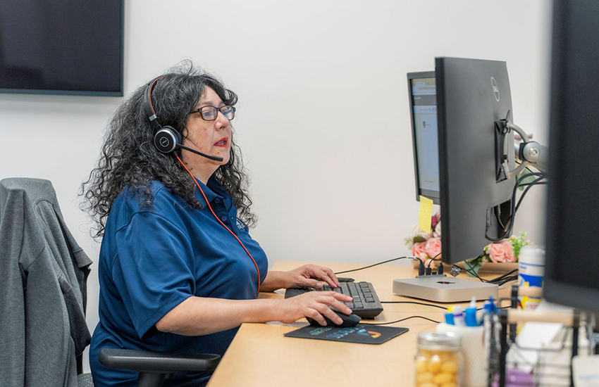 A Caccia Home Services employee talks to a customer from her desk