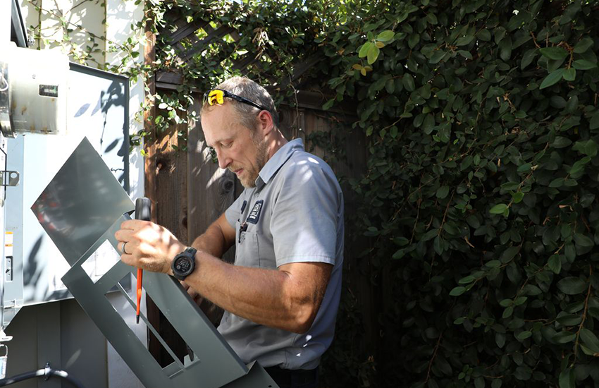 An electrician from Caccia Home Services works on a customer's electrical panel