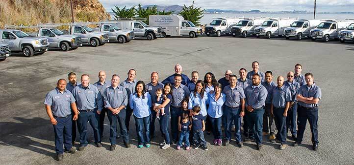 Caccia Plumbing team photo. Aerial view of team standing together in a parking lot.
