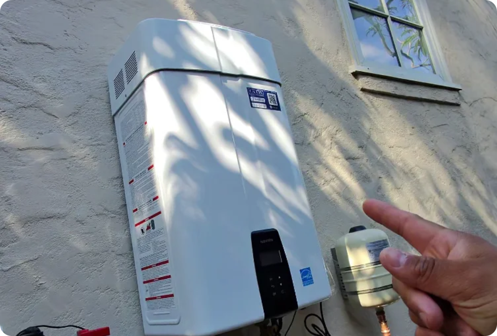 Navien NPE-240A2 tankless water heater mounted on the exterior wall with expansion tank and new copper supply lines
