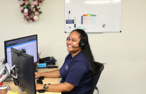 Veitoa from Caccia Home Services smiles at her desk.