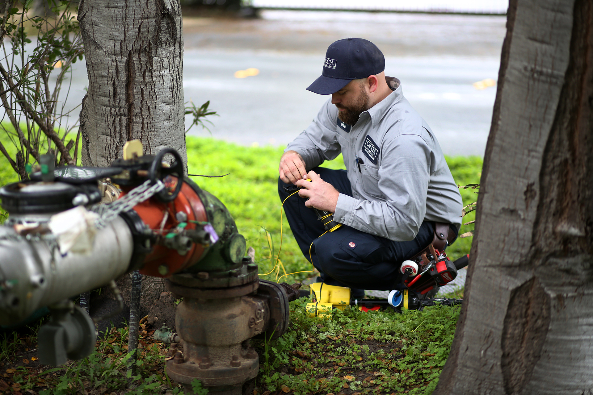 slab_leaks_caccia_plumbing Caccia technician servicing an outdoor water valve