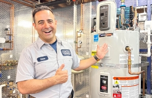 Geno from Caccia Home Services stands smiling next to a new water heater.