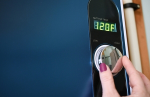 A woman adjusts the temperature on her tankless water heater.