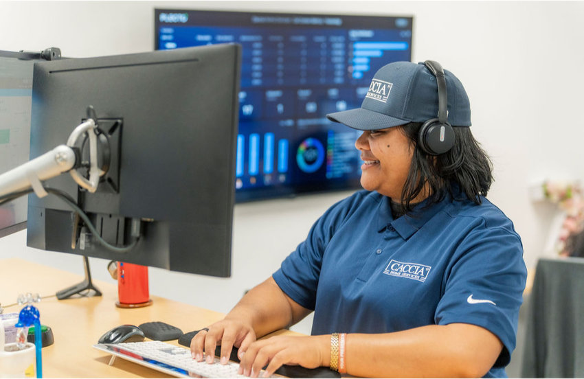 Veitoa from Caccia Home Services smiles at her desk while talking to a customer