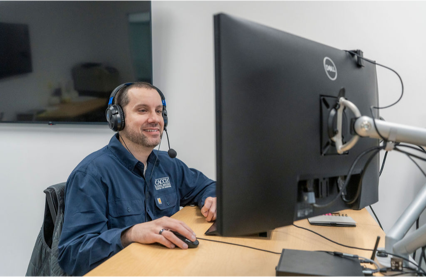 A customer support agent from Caccia Home Services takes a call at his desk