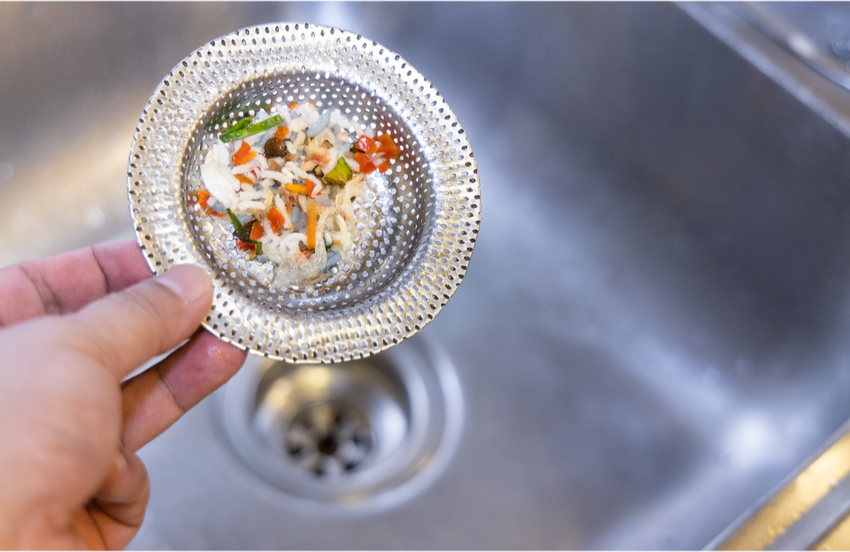 Different Sewer Types in California & How to Prevent Them from Clogging 5 A common silver drain strainer for a kitchen sink with food debris in it