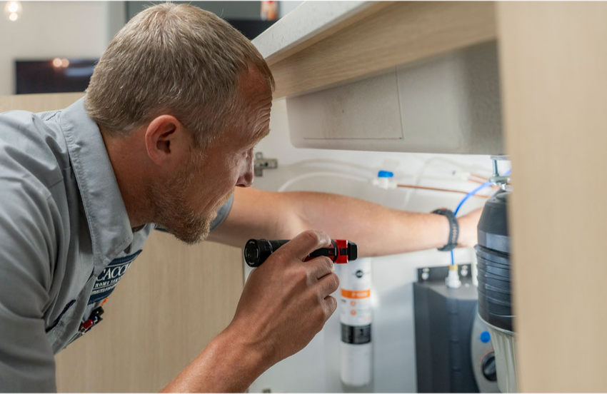 A Caccia Home Services employee inspects a customer's water filtration system