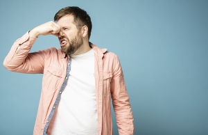 A man pinches his nose due to smelly bathroom odors