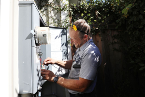 A Caccia Home Services electrician works on a customer's electric panel.